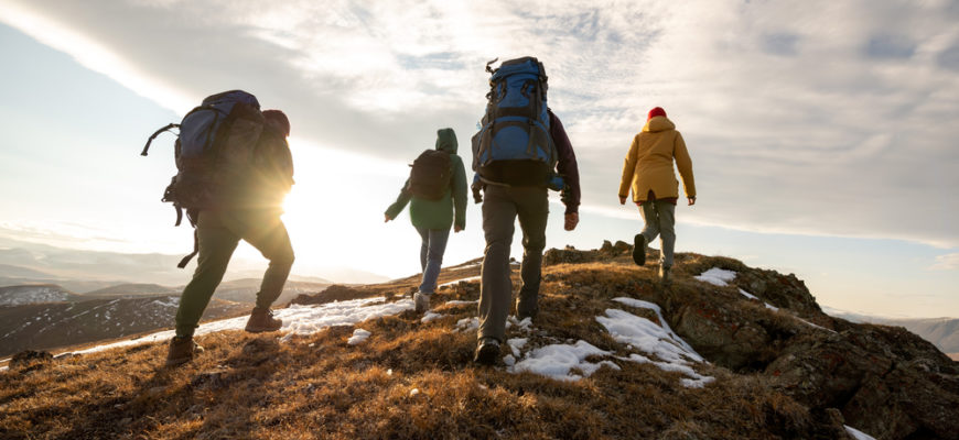 Group,Of,Four,Hikers,With,Backpacks,Walks,In,Mountains,At